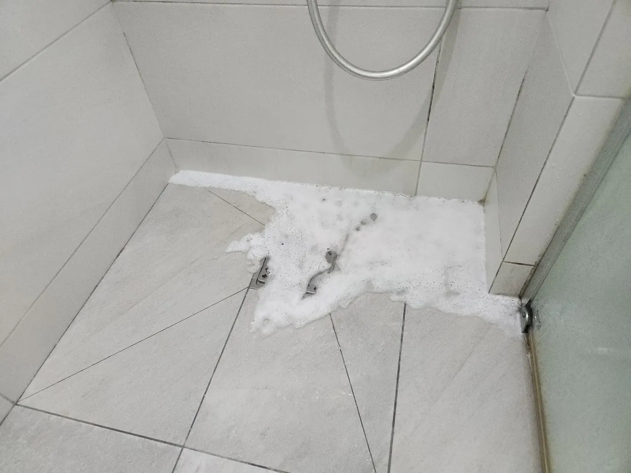 배수구에서 거품 섞인 물이 올라온 샤워실 바닥
